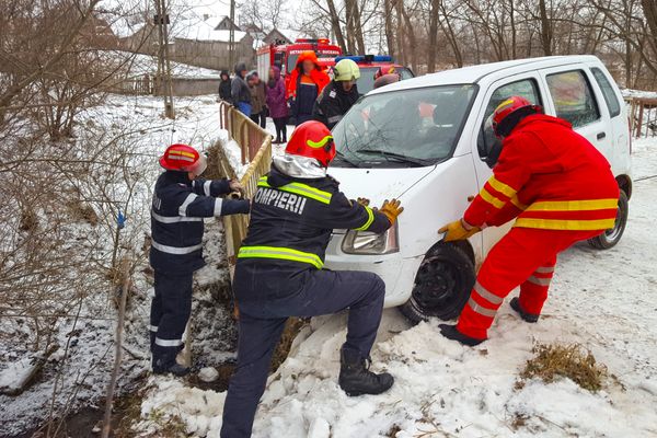 Autoturism în pericol de prăbușire în albia unui pârâu. O persoană a rămas prinsă în interior VIDEO