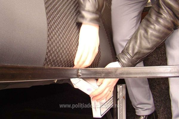 Ţigări de contrabandă, ascunse în bancheta din spate a unui microbuz 